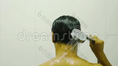 亚洲男人的后背浴室里手里拿着淋浴的水